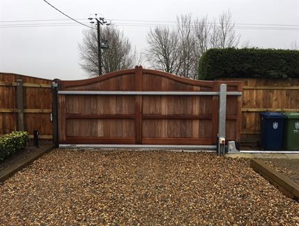 Sliding gates illustrating slide mechanism with wooden fencing